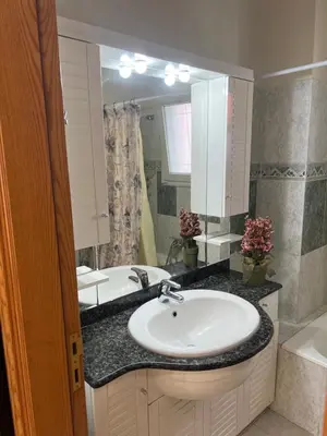 a bathroom with a sink and a large mirror at Cozy Kolonaki Retreat in Kremasti
