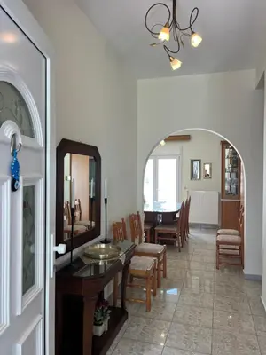 a dining room with a table and chairs and a mirror at Cozy Kolonaki Retreat in Kremasti