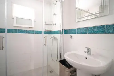 a bathroom with a sink and a shower at La Casa di Symi - Central Apartment with View in Symi