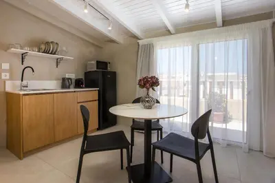 a kitchen with a table and chairs and a kitchen with a window at New Town Deluxe Loft in Rhodes Town