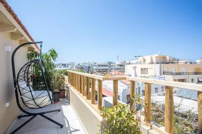 a balcony with a chair and a view of a city at New Town Deluxe Loft in Rhodes Town