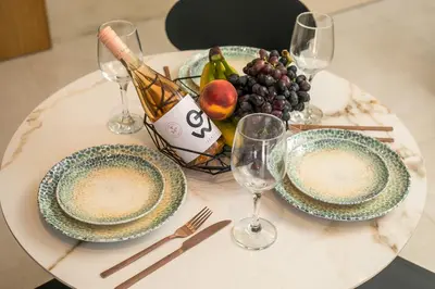 a table with two plates and wine glasses on it at New Town Deluxe Loft in Rhodes Town