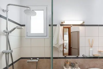 a bathroom with a shower and a sink and a mirror at Calypso Lindia Luxury Villa in Líndos