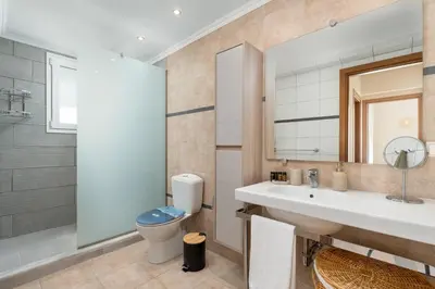 a bathroom with a sink and a toilet and a mirror at Calypso Lindia Luxury Villa in Líndos