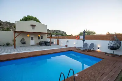 a villa with a swimming pool and a house at Garden Olive Luxury Villa in Archangelos