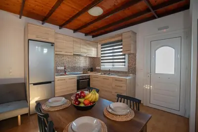 a kitchen with a table with a bowl of fruit on it at Garden Olive Luxury Villa in Archangelos