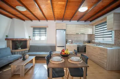 a kitchen with a table with a bowl of fruit on it at Garden Olive Luxury Villa in Archangelos