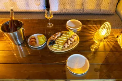 a table with a plate of food and glasses of wine at White Memories boutique home - Romantic Stay in Rhodes in Afantou