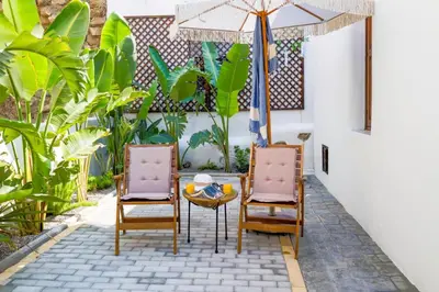 two chairs and a table with an umbrella on a patio at White Memories boutique home - Romantic Stay in Rhodes in Afantou