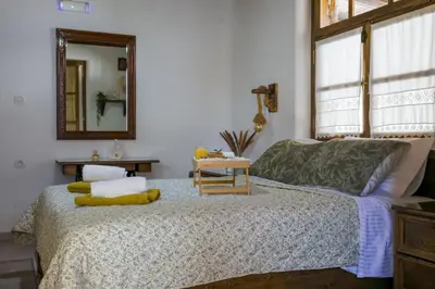 a bedroom with a bed with a mirror and a table at White Memories boutique home - Romantic Stay in Rhodes in Afantou