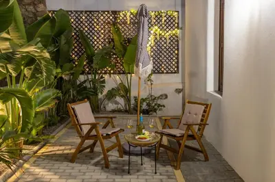 a patio with chairs and a table and umbrella at White Memories boutique home - Romantic Stay in Rhodes in Afantou