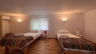two beds in a small room with a window at Radiki in Gennadi