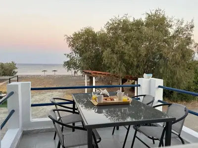 a table with a tray of food on a balcony overlooking the beach at Radiki in Gennadi