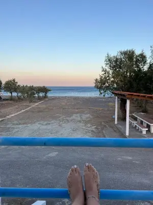 a person with their feet up on a railing looking at the beach at Radiki in Gennadi