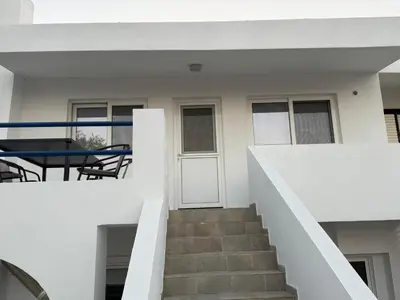 a staircase leading up to a white house with a table at Radiki in Gennadi