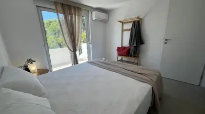 a bedroom with a large white bed and a window at Radiki in Gennadi