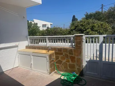a house with a white fence and a green hose at Gennadi Sunrise in Gennadi