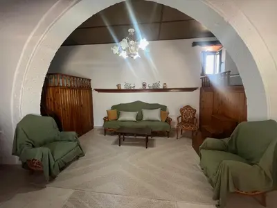 a living room with two green chairs and a chandelier at Gennadi Sunrise in Gennadi