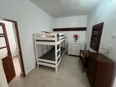 a room with a white bunk bed and a dresser at Gennadi Sunrise in Gennadi