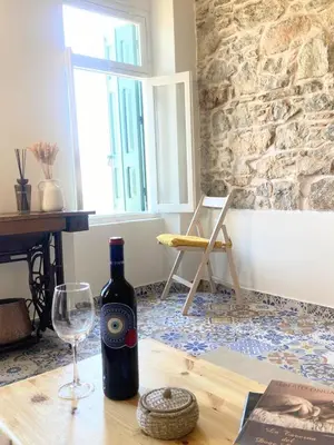 a bottle of wine and a glass on a table at ALEMINAS House 2 in Symi