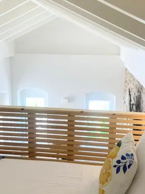 a bedroom with wooden blinds on the window at ALEMINAS House 2 in Symi