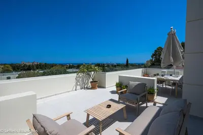 a patio with chairs and a table on a roof at Rodos Suites on the Park in Rhodes Town