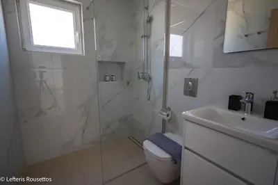 a bathroom with a shower and a toilet and a sink at Rodos Suites on the Park in Rhodes Town