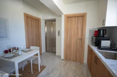 a kitchen with a white table and a microwave at Rodos Suites on the Park in Rhodes Town
