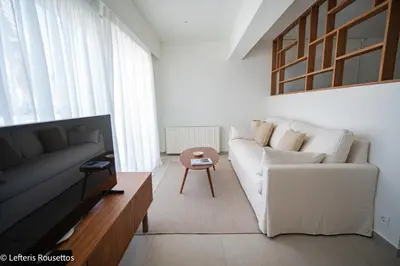 a living room with a white couch and a table at Rodos Suites on the Park in Rhodes Town