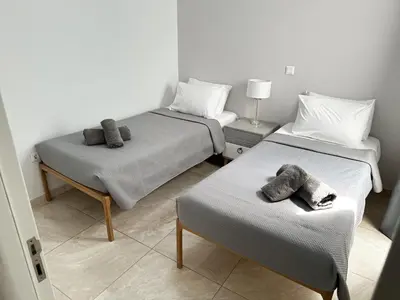 a room with two beds with towels on them at Seabreeze By Ro in Rhodes Town