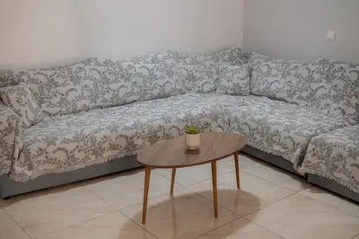 a couch with a table in a living room at Seabreeze By Ro in Rhodes Town