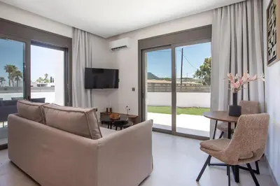 a living room with a couch and chairs and a table at Nostos Luxury Apartments in Kremasti