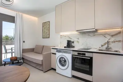 a kitchen with a washer and dryer in a room at Nostos Luxury Apartments in Kremasti