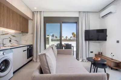 a kitchen and living room with a couch and a table at Nostos Luxury Apartments in Kremasti