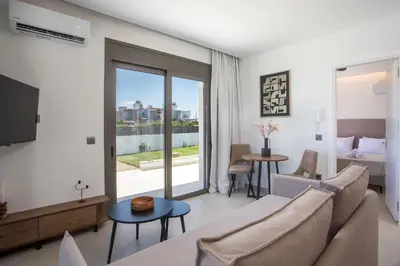 a living room with a couch and a tv at Nostos Luxury Apartments in Kremasti