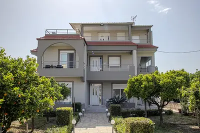 a large house with trees in front of it at ELMA apartment 2 Kremasti in Kremasti