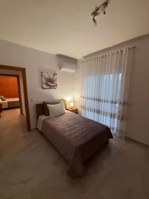 a bedroom with a bed and a large window at ELMA apartment 2 Kremasti in Kremasti