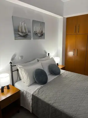 a bedroom with a bed with two blue pillows on it at ELMA apartment 2 Kremasti in Kremasti