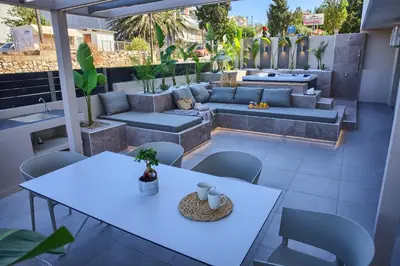 a patio with white tables and chairs and a couch at Casa De Sario in Rhodes Town