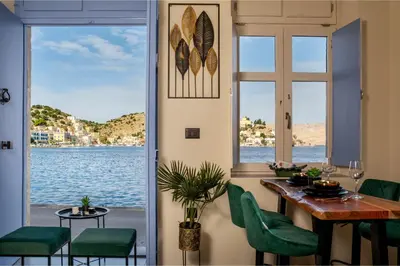 a dining room with a table and a view of the water at Symi's Jewel in Symi