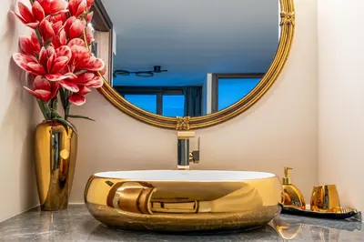 a bathroom with a gold sink and a mirror at Symi's Jewel in Symi