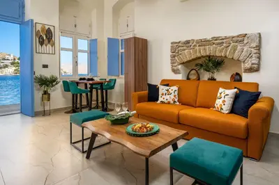 a living room with an orange couch and a table at Symi's Jewel in Symi