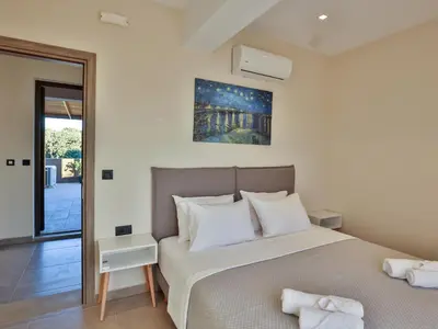 a bedroom with a large bed with white pillows at Bliss Sunrise Penthouse in Asgourou