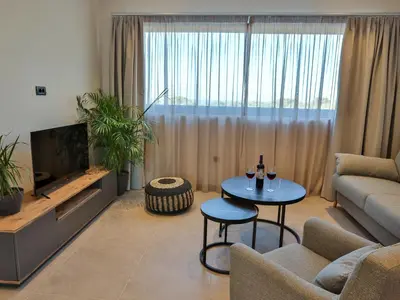 a living room with a couch and a table at Bliss Sunrise Penthouse in Asgourou