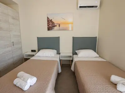 a room with two beds and a painting on the wall at Bliss Sunrise Penthouse in Asgourou