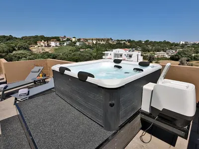 a hot tub on the roof of a house at Bliss Sunrise Penthouse in Asgourou
