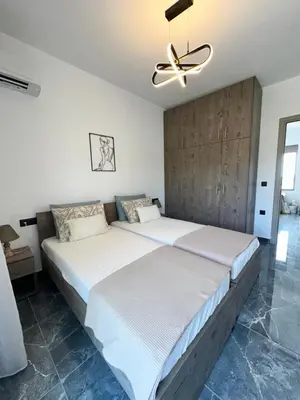 a bedroom with two beds and a ceiling fan at Villa Mike in Rhodes Town