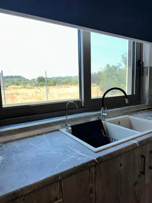 a kitchen sink with two faucets and a window at Villa Mike in Rhodes Town