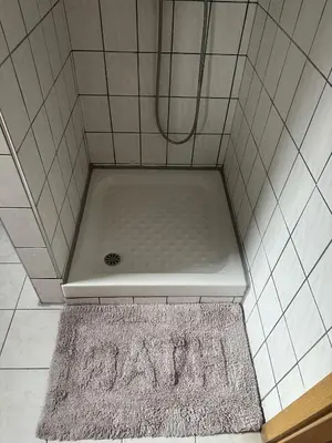 a shower with a bath tub with a rug in a bathroom at Κakle Kolympia Apartments in Kolimbia