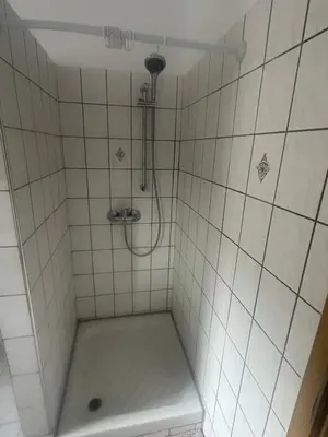 a white tiled shower with a shower head at Κakle Kolympia Apartments in Kolimbia
